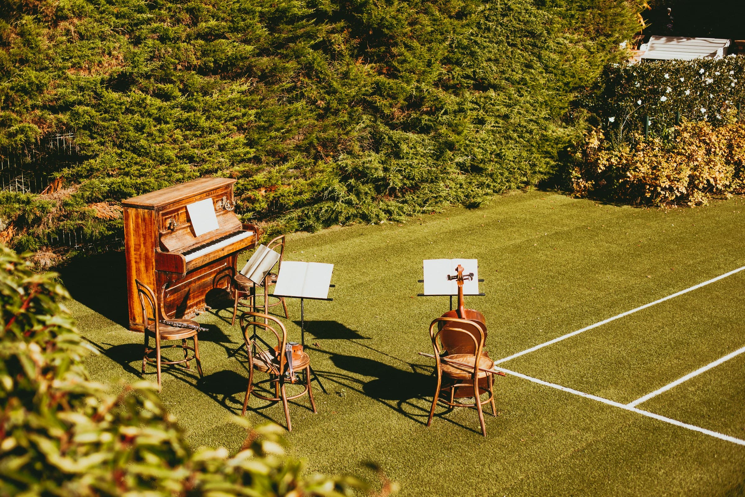Wedding ceremony setup with piano, cello, and other musical instruments and stands