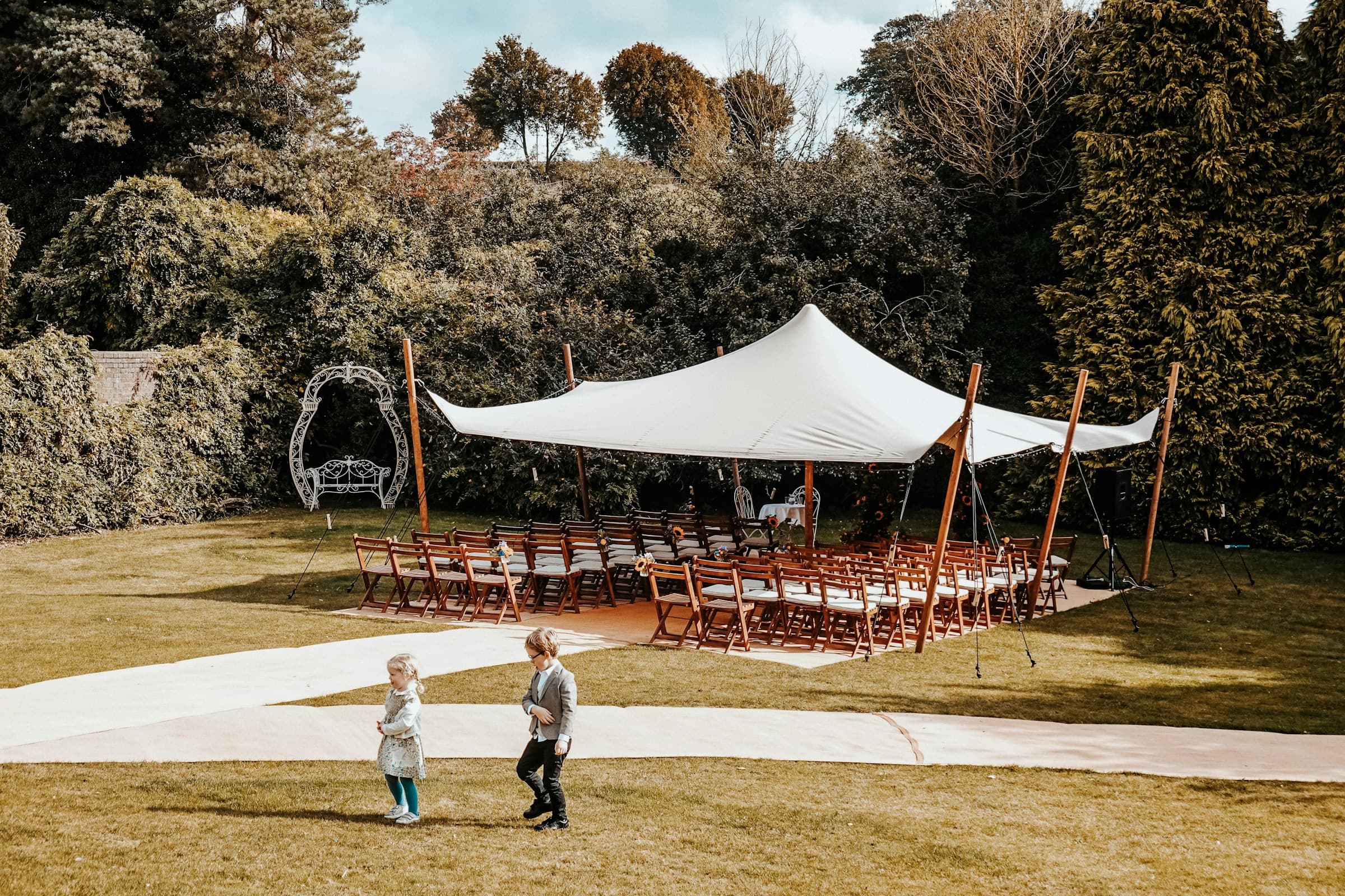Wedding ceremony under white tent with chairs for guests