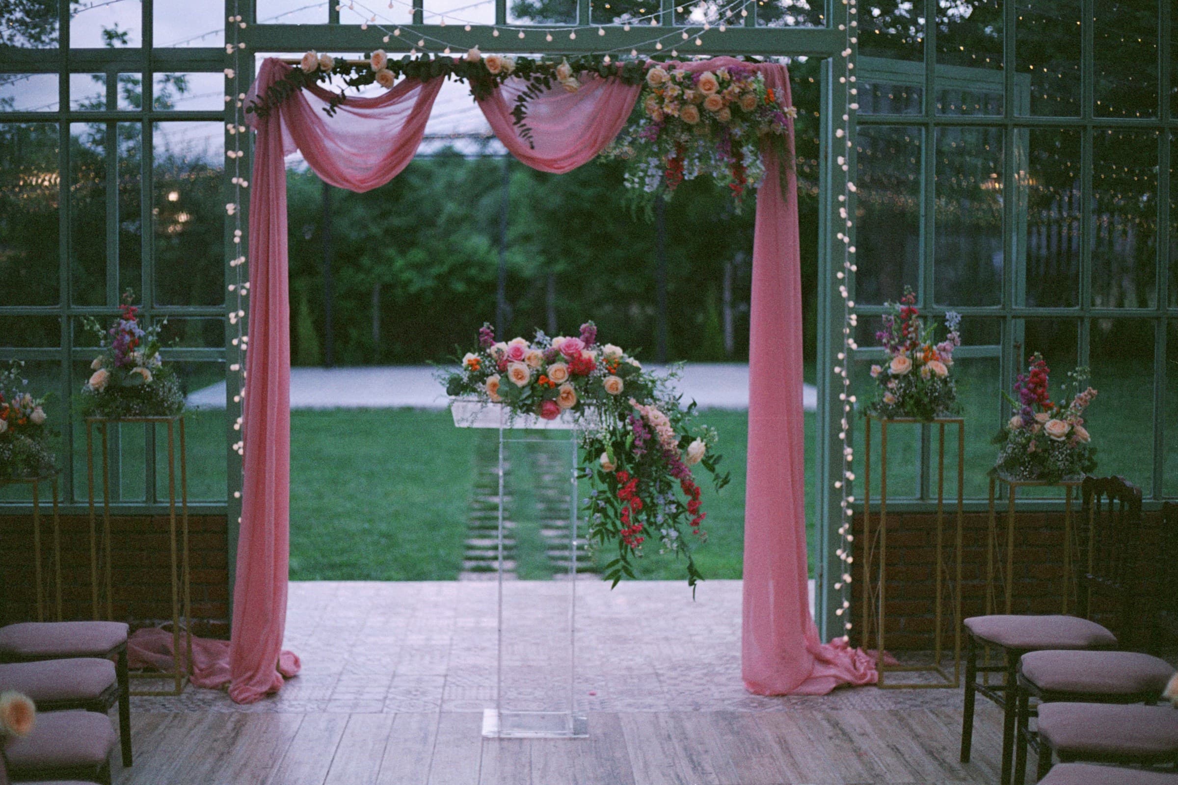 Wedding arch with pink linen drape and flowers running down