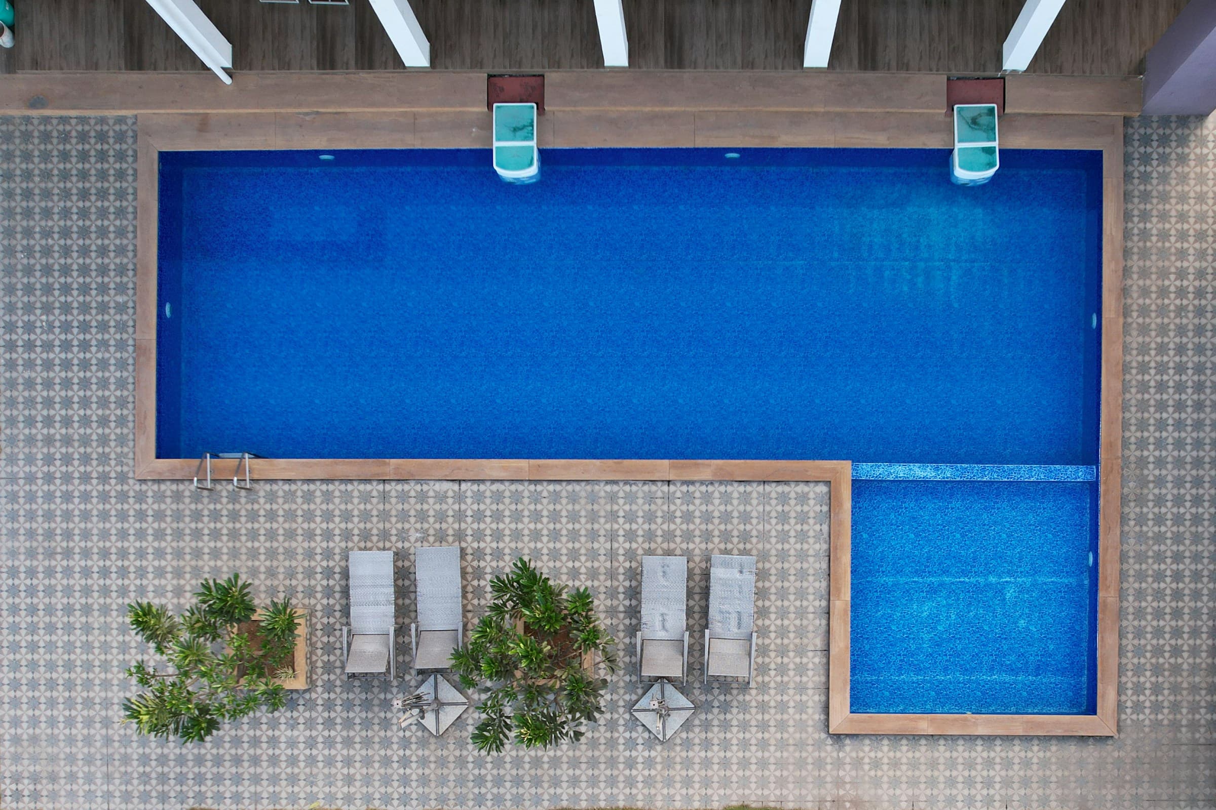 Overhead view of spa with bright blue pool and reclining chairs to relax