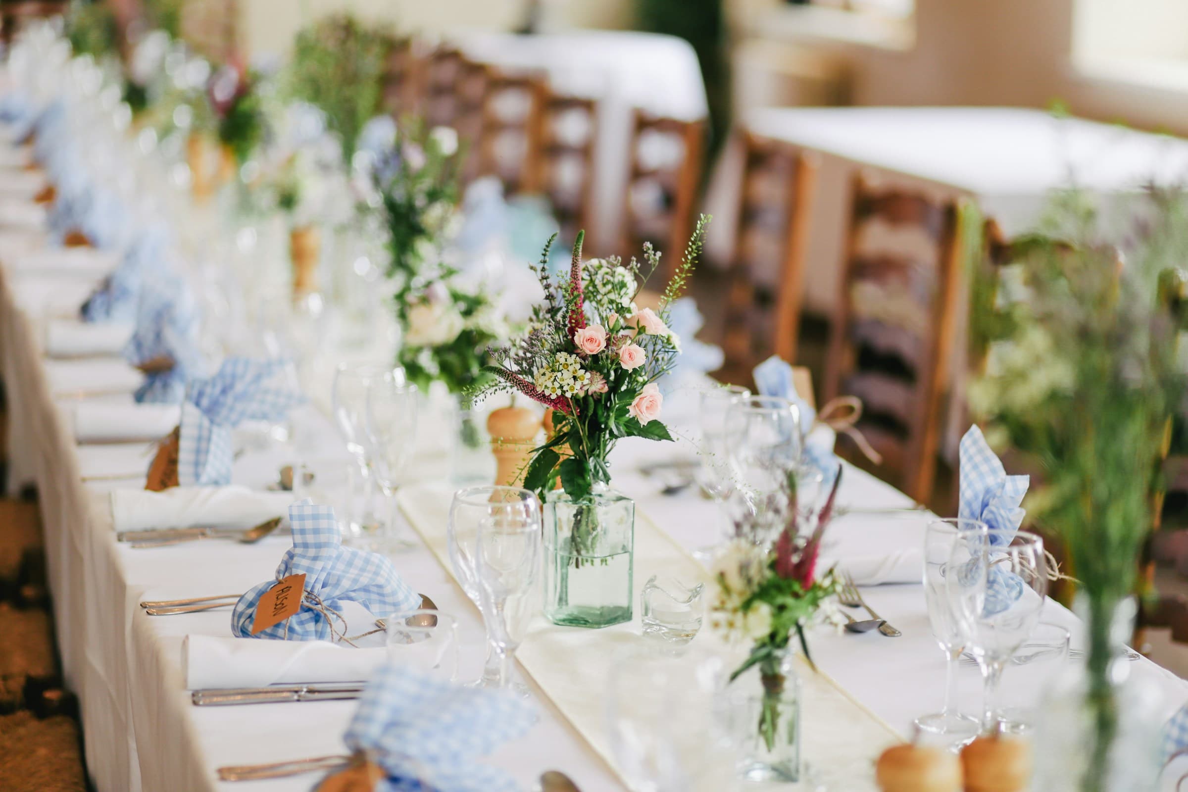 White wedding table linens and chairs with flowers and tableware